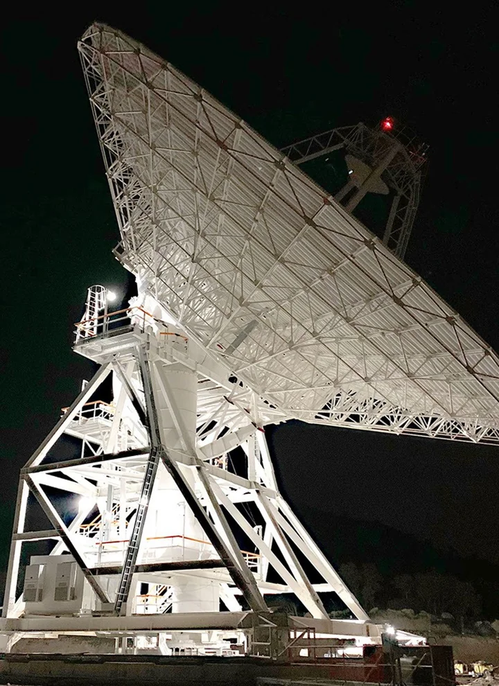 The illuminated DSS-53 ground-station antenna of the Deep Space Network near Madrid at night.