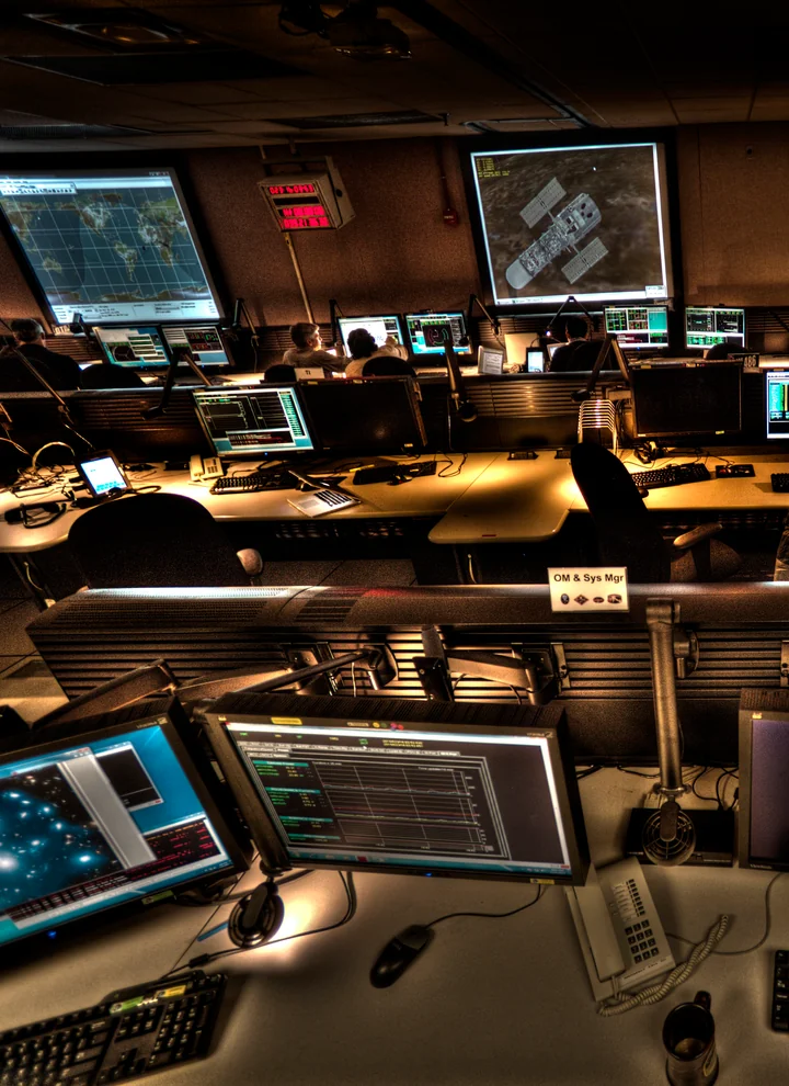 Consoles and scientific displays in the Hubble Space Telescope operations room at NASA Goddard.